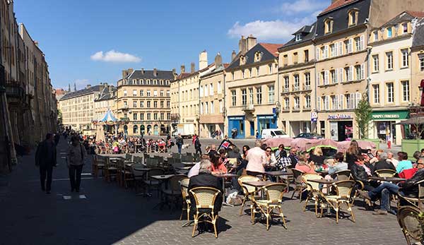 On a pretty day in Metz, cafes are brimming with people sitting outdoors.